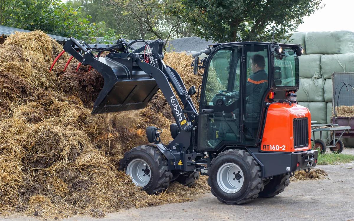 Kubota RT160-2 mit Greifschaufel beim Bewegen von organischem Material