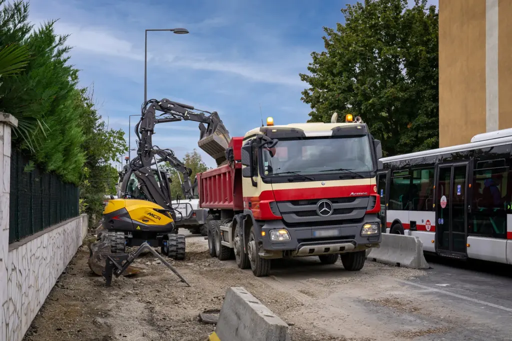 Mecalac 8MCR belädt einen Lkw auf einer engen Stadtbaustelle