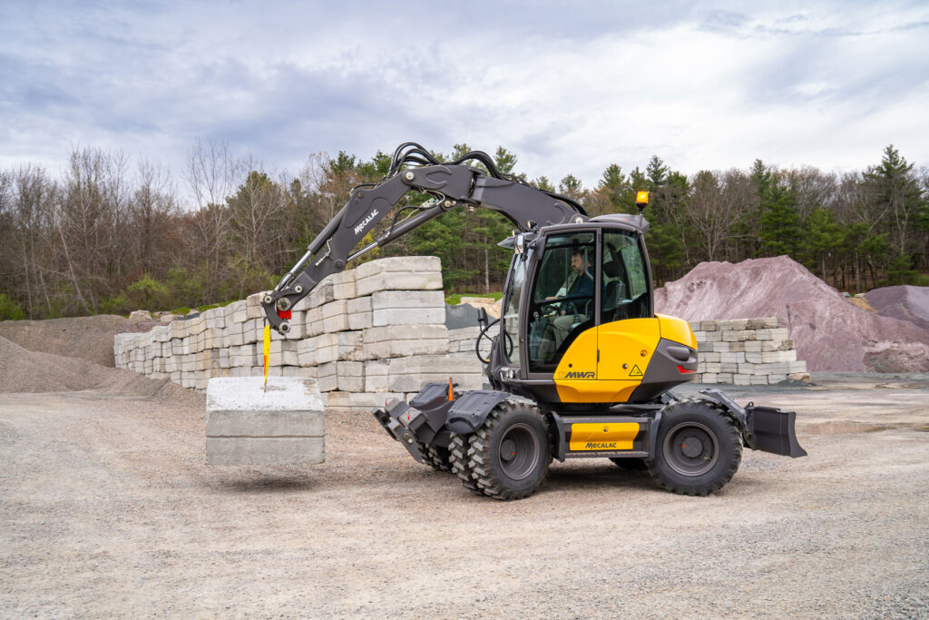 Mecalac 11MWR beim Heben eines Betonblocks