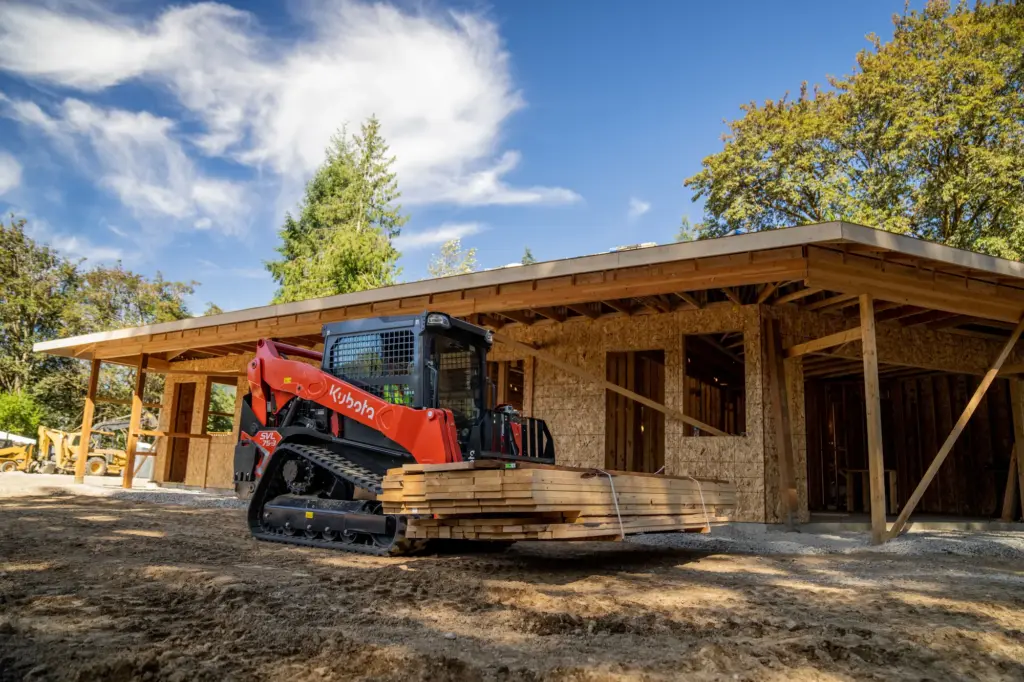 Kubota SVL75-3 transportiert Bauholz auf einer Baustelle